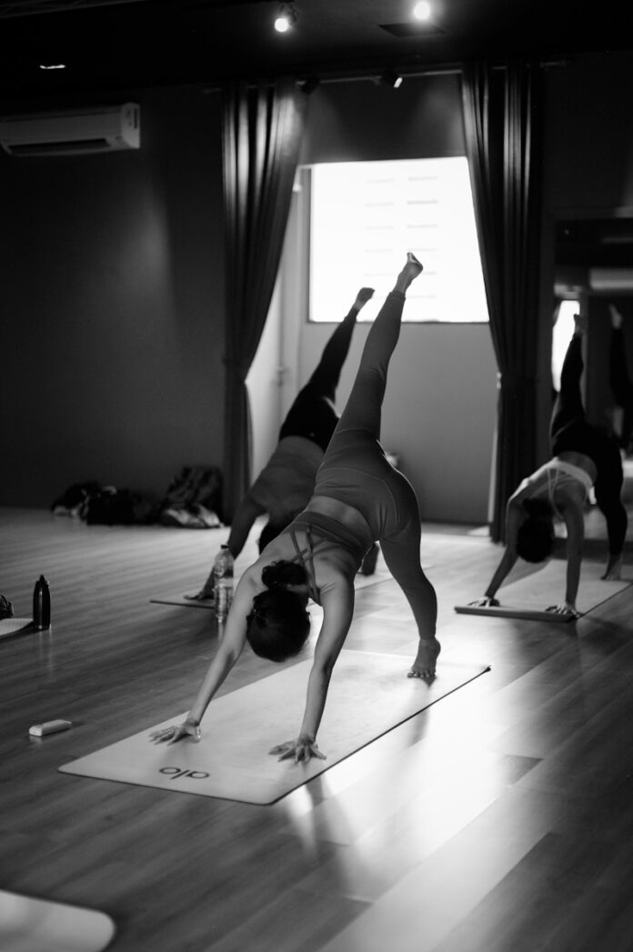 a group of people doing yoga in a room