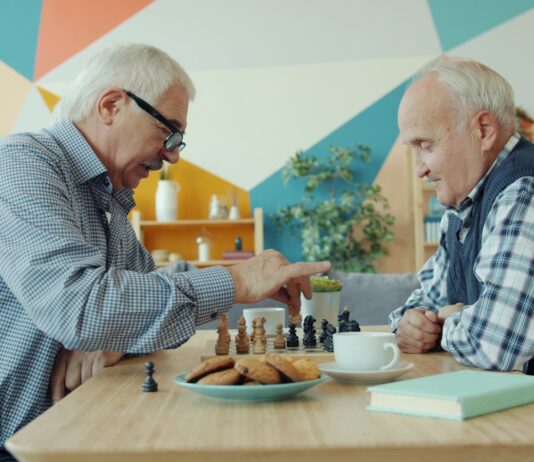 “노화의 시계를 늦춰라”… 젊은 층이 ‘슬로우 조깅’에 열광하는 이유 Two elderly men playing chess at a table.