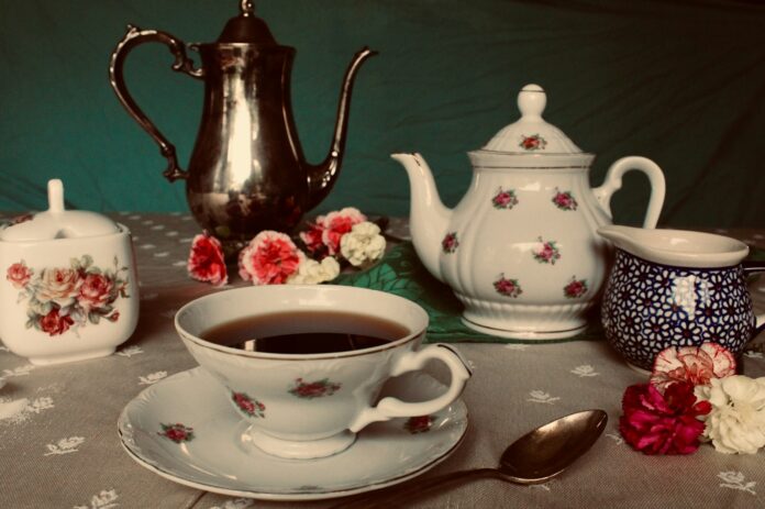 white and red floral ceramic teapot on table