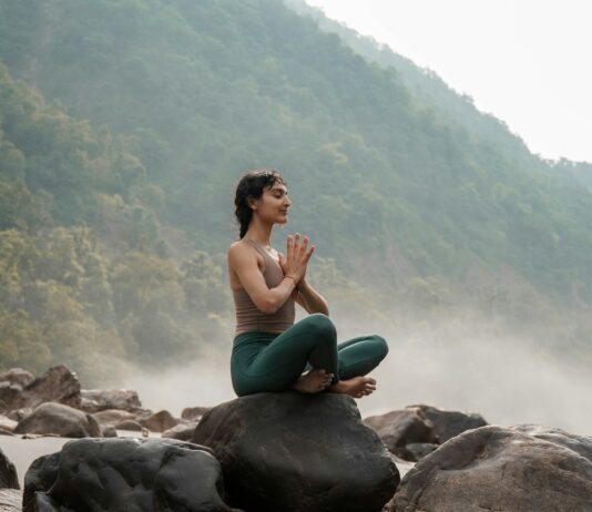 “슬기로운 아침 루틴으로 활기찬 하루 열기” – 건강 트렌드와 함께하는 실천법 a woman sitting on top of a rock next to a river
