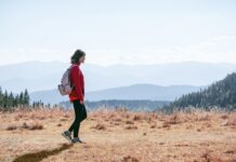 직장인 건강 지키는 ‘걷기 챌린지’, 일상 속 움직임으로 활력 UP a man with a backpack walking across a dry grass covered field